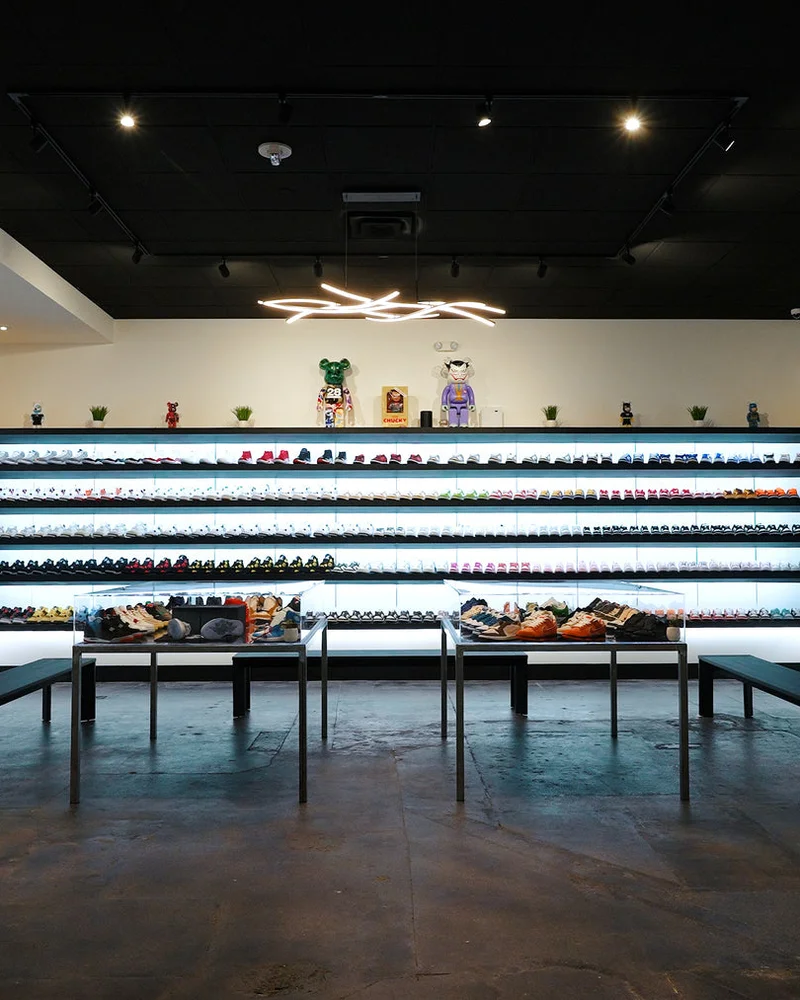 Inside the Common Hype store, with lit sneaker walls wrapping around a dark showroom floor.